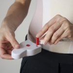 Man demonstrating how to use a tape measure on his waist