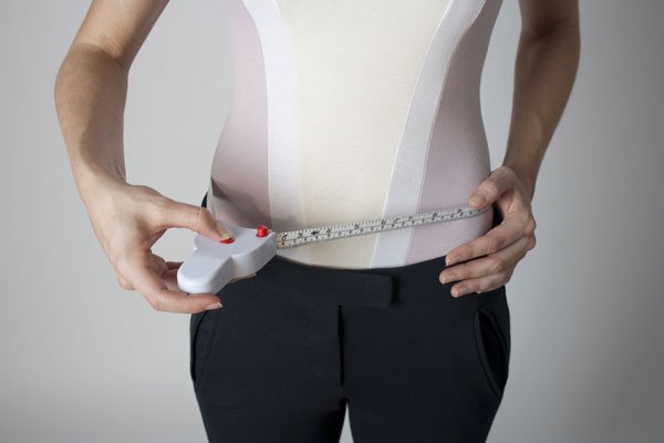 man measuring their waist and showing how to do