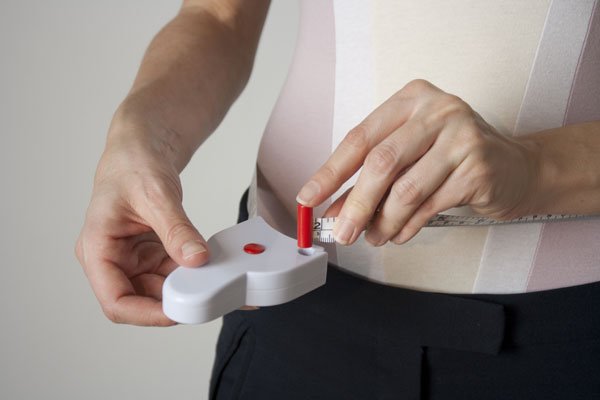 man measuring his waist