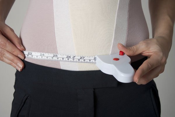 Man using tape measure from Perfect Measuring Tape to measure their waist